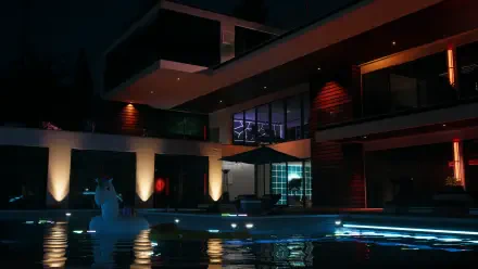 A stunning 4K Ultra HD wallpaper featuring a modern house at night, illuminated by pool lights, inspired by the aesthetics of the video game Dead Island 2.