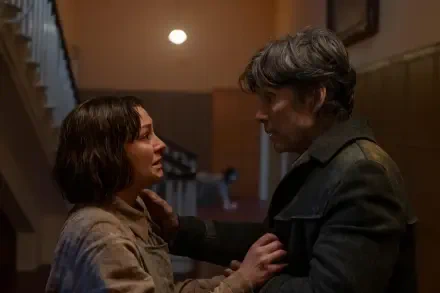 Emotional scene from the movie Small Things Like These featuring Cillian Murphy. The image captures a tense moment between two characters in a dimly lit setting.