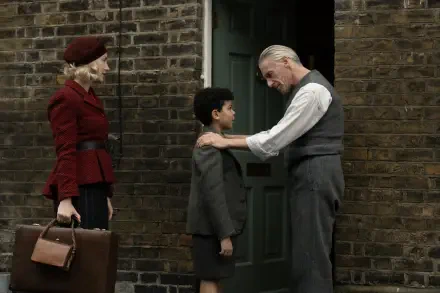 A scene from the movie Blitz (2024), featuring a woman in a red coat, a boy in a suit, and an elderly man in a vest, set against a brick wall and door backdrop. 8K Ultra HD quality.