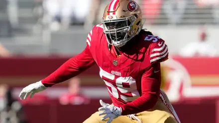 De'Vondre Campbell in action for the San Francisco 49ers, showcasing his athleticism in a vibrant red and gold uniform during an NFL game. A striking HD wallpaper for football fans.