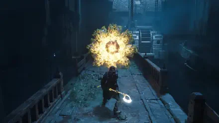 A character in Hell is Us stands on a crumbling pathway, wielding a glowing weapon as an explosion of energy surrounds them, creating a dramatic and intense atmosphere.