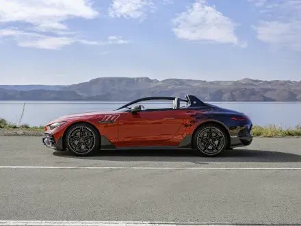 A striking Mercedes-AMG PureSpeed sports car in vibrant red parked on a scenic road, with mountains and a tranquil lake in the background. 4K Ultra HD wallpaper.