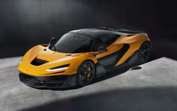 A striking McLaren W1 in vibrant orange and black, showcasing its aerodynamic design against a minimalist backdrop. This 8K Ultra HD image makes a bold statement for any desktop.