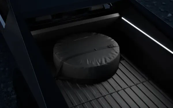 Close-up view of a Tesla Cybertruck's bed, featuring a round storage cover and sleek interior lighting, showcased as a 4K Ultra HD desktop wallpaper.