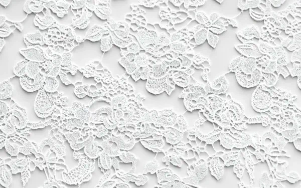 A detailed white lace pattern fills the image, showcasing intricate floral designs. This beautiful lace serves as a 4K Ultra HD desktop wallpaper and background.