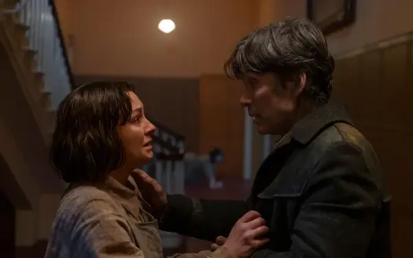 Emotional scene from the movie Small Things Like These featuring Cillian Murphy. The image captures a tense moment between two characters in a dimly lit setting.