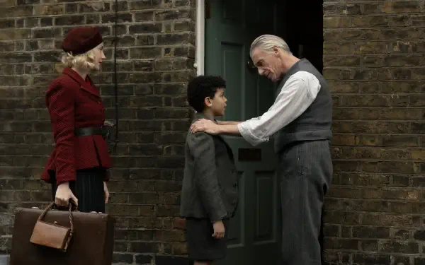 A scene from the movie Blitz (2024), featuring a woman in a red coat, a boy in a suit, and an elderly man in a vest, set against a brick wall and door backdrop. 8K Ultra HD quality.