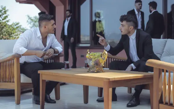 Scene from the TV show The Pit featuring two men in conversation at an outdoor seating area, captured in a 4K Ultra HD PC desktop wallpaper and background.