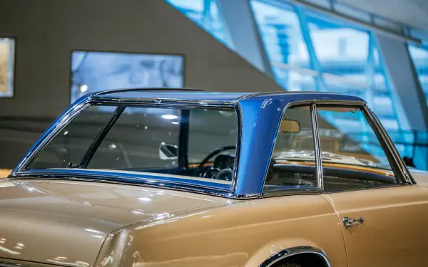 A close-up of a Mercedes-Benz 230 SL showcasing its classic design, featuring a distinctive blue hardtop and elegant lines, set against a modern background in this stunning 4K Ultra HD wallpaper.