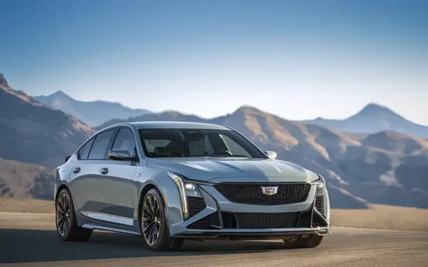 A sleek Cadillac CT5-V Blackwing parked against a stunning mountain backdrop, featuring a modern design and high-performance details. An 8K Ultra HD desktop wallpaper.
