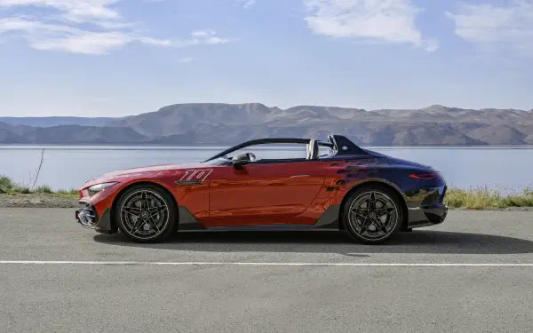 A striking Mercedes-AMG PureSpeed sports car in vibrant red parked on a scenic road, with mountains and a tranquil lake in the background. 4K Ultra HD wallpaper.