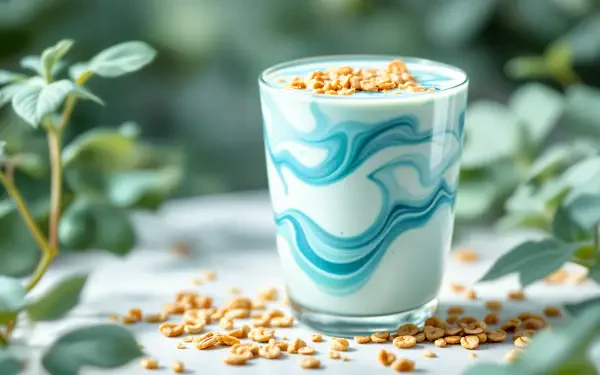 A blue and white swirled yogurt smoothie topped with granola, set against a softly blurred green background, presented as a 4K Ultra HD desktop wallpaper.