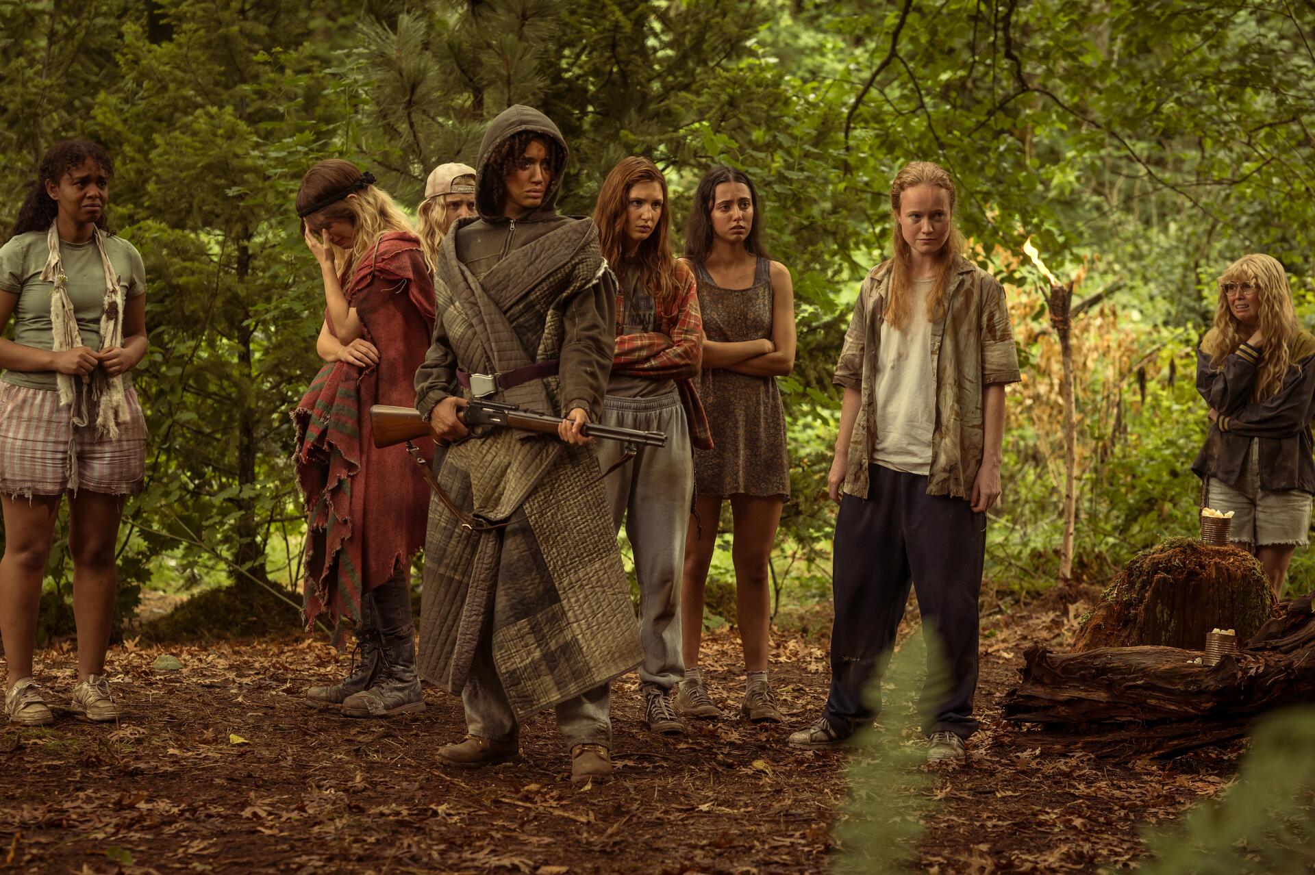 A scene from the TV show Yellowjackets, featuring a group of girls in a forest setting, showcasing their survival struggle with a mix of tension and camaraderie. 4K Ultra HD quality.