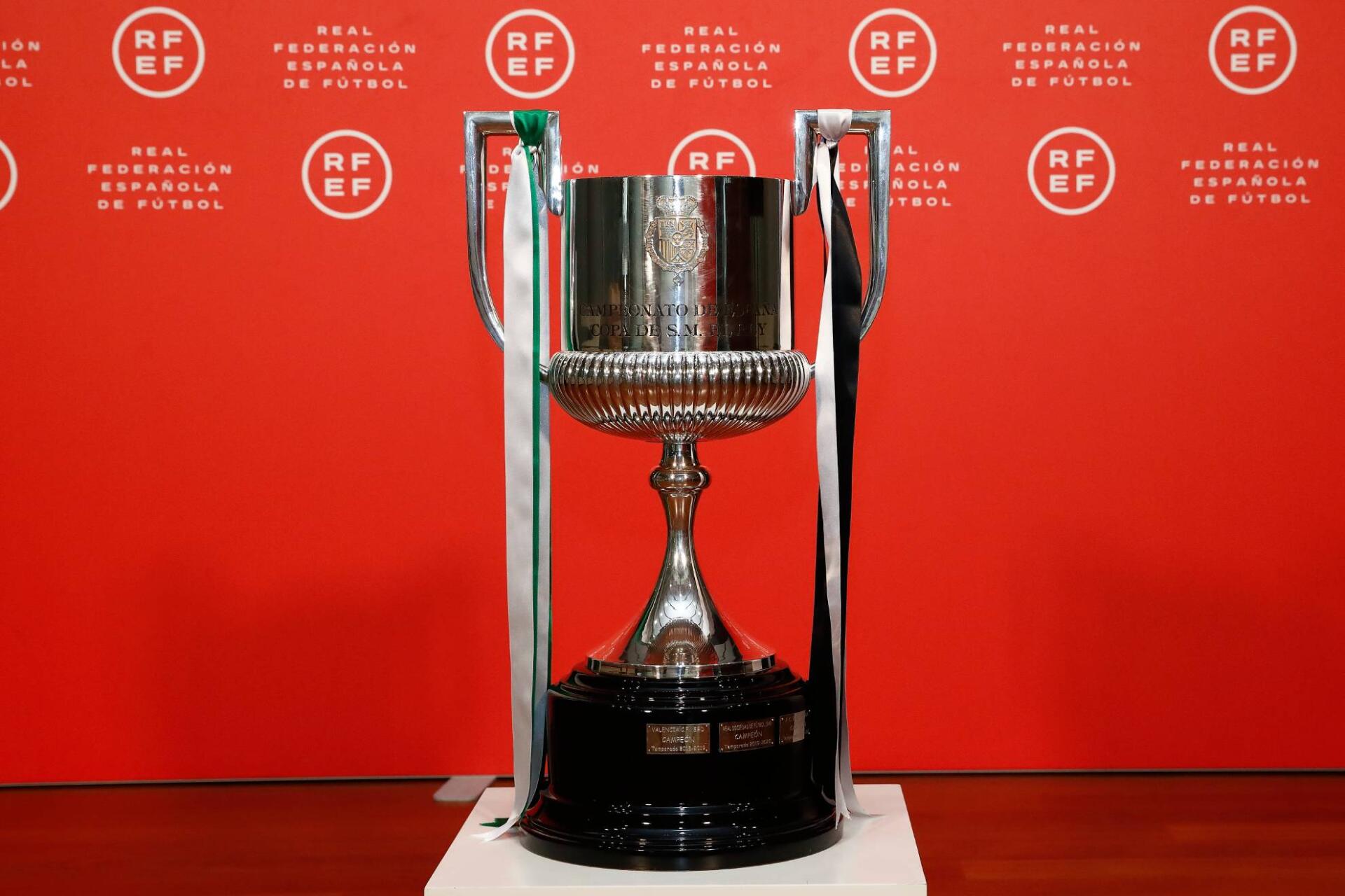 Shiny Copa del Rey trophy displayed against a vibrant red backdrop, symbolizing soccer excellence. This HD image serves as a striking desktop wallpaper.