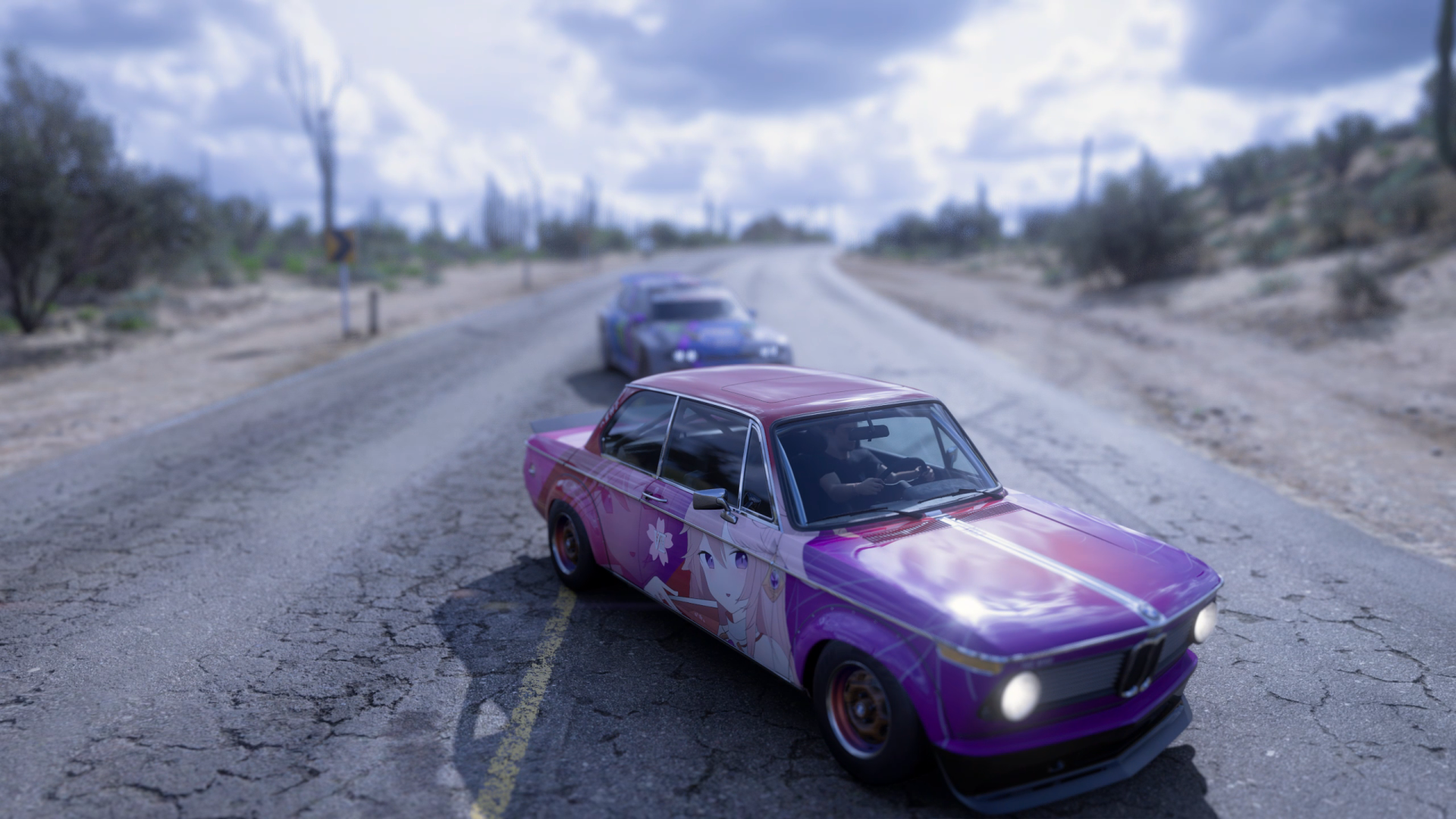 Forza Horizon 5 2K Quad HD PC desktop wallpaper: purple vintage race car with a star decal leads a blue rival along a cracked, dusty road under dramatic clouds.