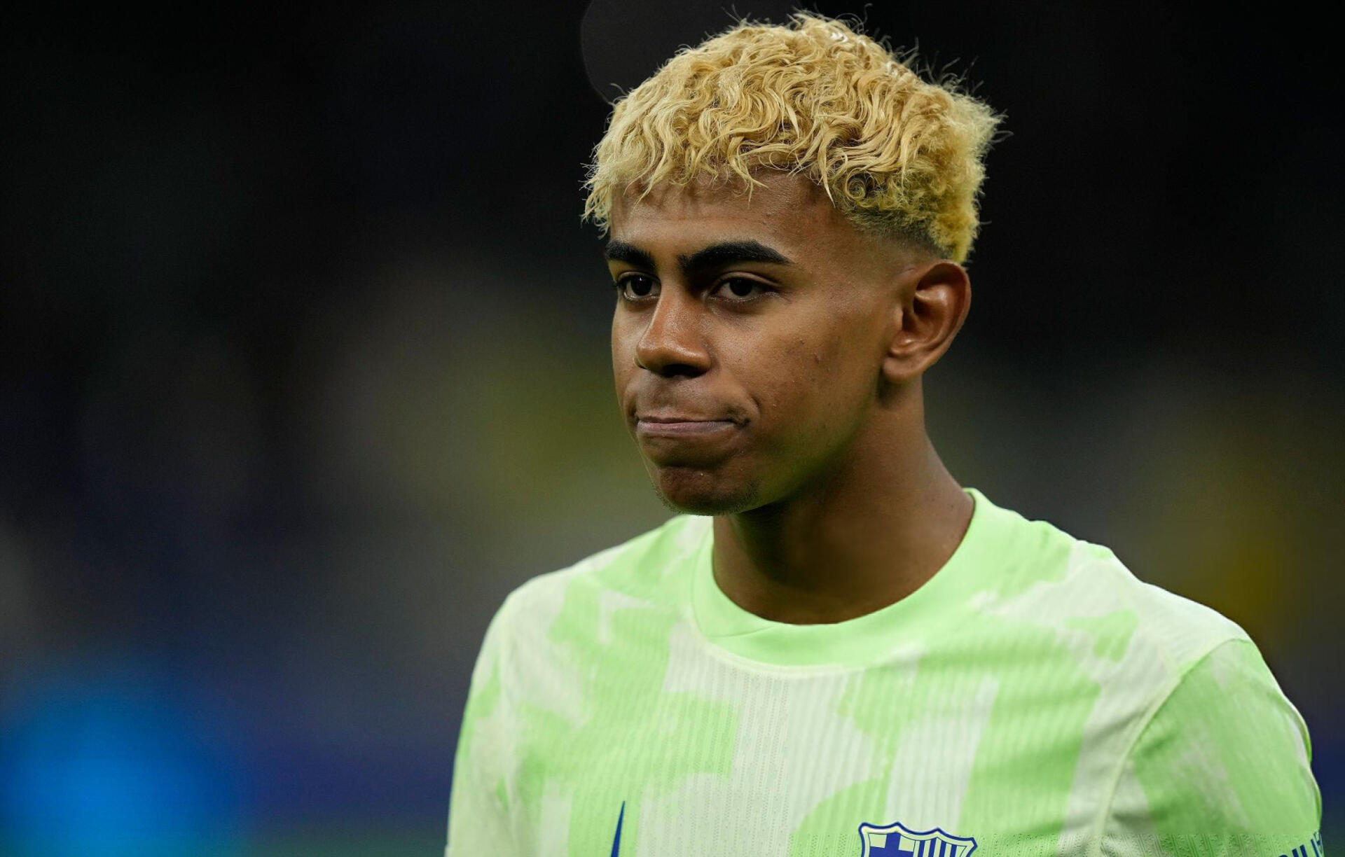 HD PC desktop wallpaper featuring FC Barcelona soccer player Lamine Yamal in a light green training jersey against a blurred dark background.