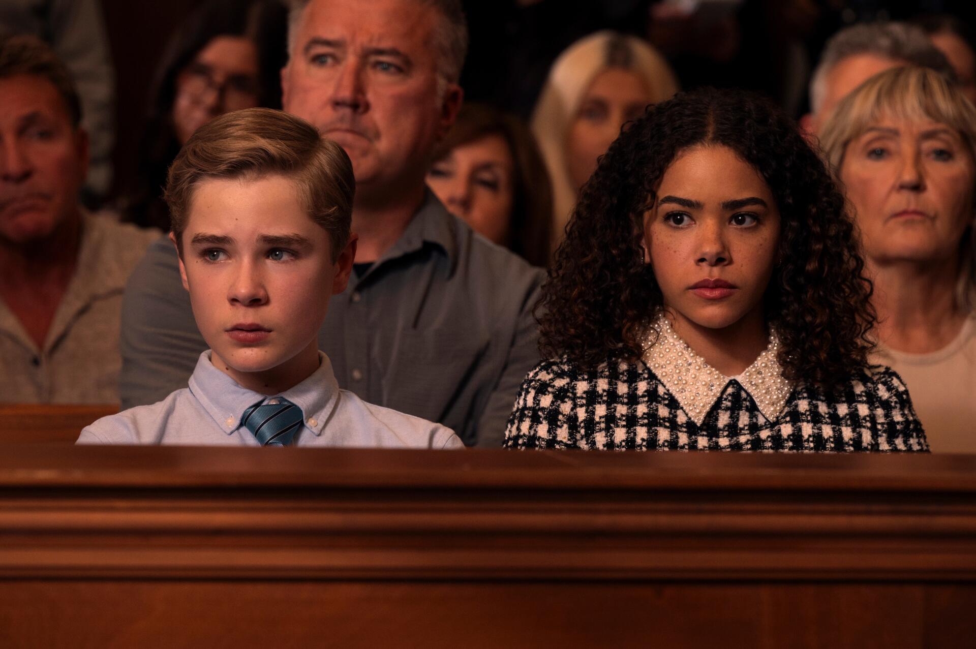 HD PC desktop wallpaper featuring a scene from the TV show Ginny & Georgia with two main characters seated among a serious audience.