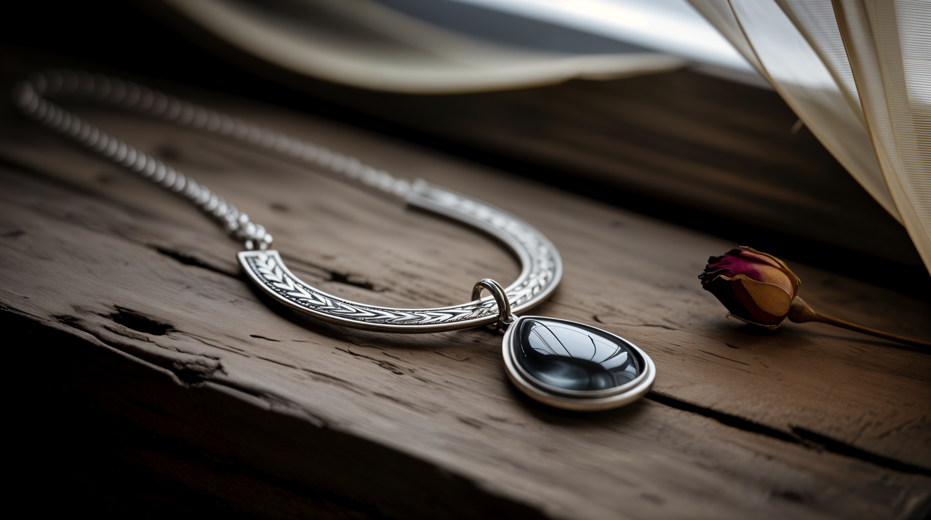 Close-up of an elegant necklace with a teardrop-shaped black pendant resting on weathered wood, captured in stunning 4K Ultra HD for a PC desktop wallpaper.