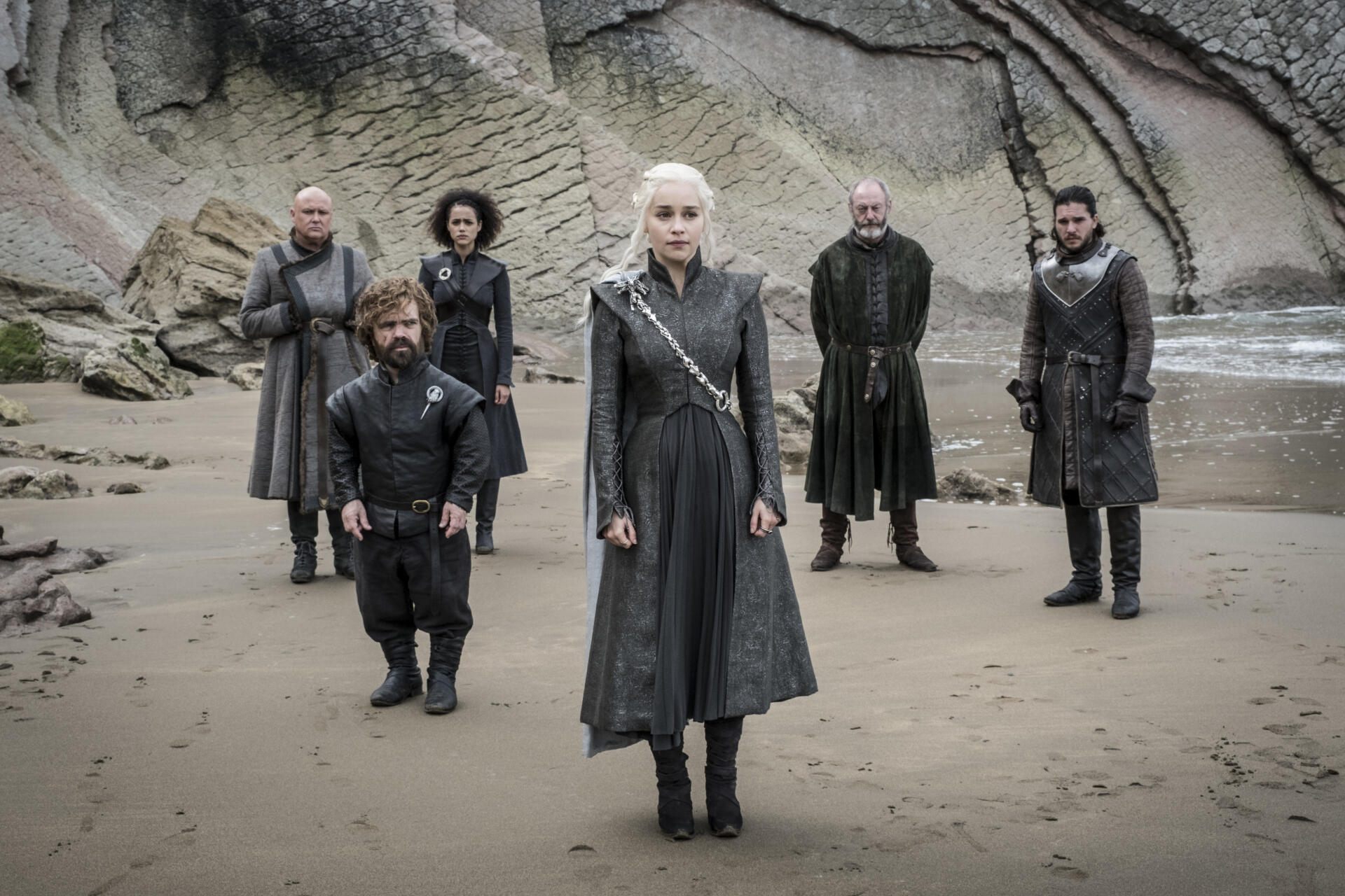 HD Game of Thrones desktop wallpaper featuring key characters standing on a rocky beach with a dramatic, overcast sky.