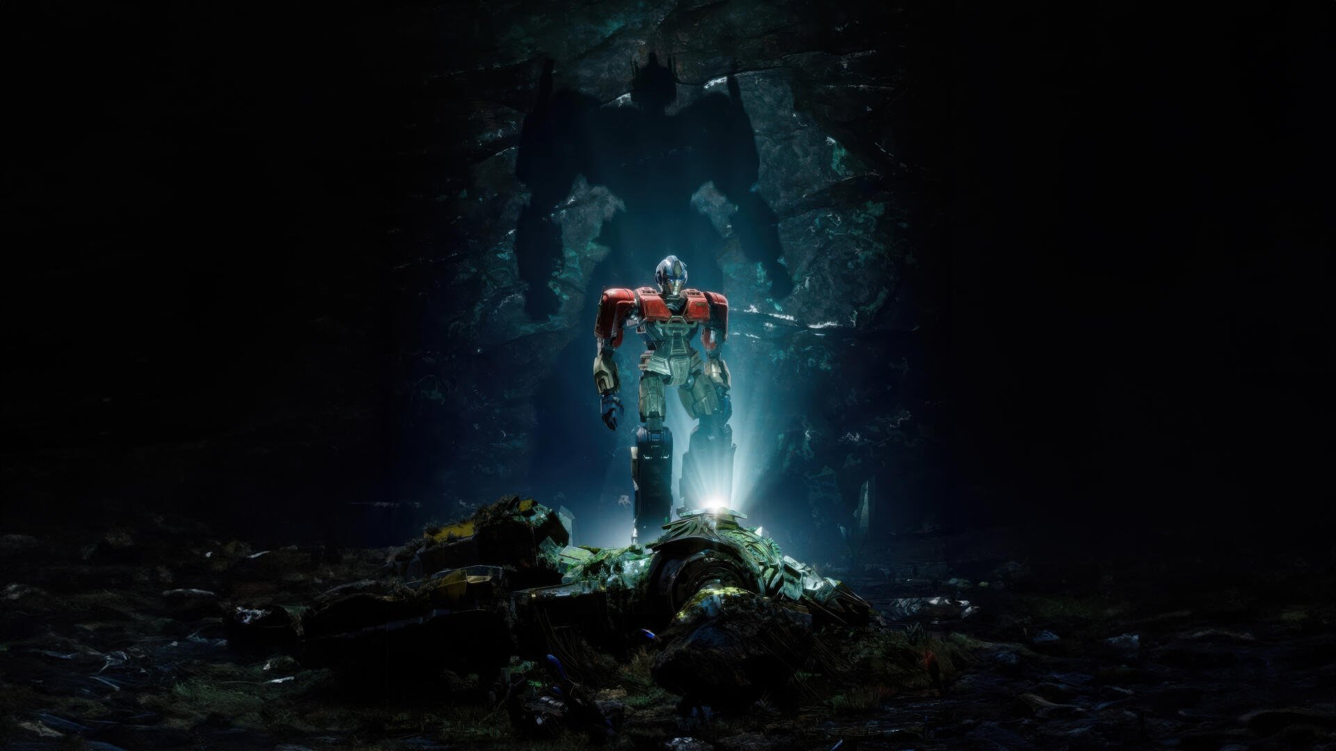 A 4K Ultra HD PC desktop wallpaper featuring Optimus Prime from Transformers One standing illuminated in a dark, cavernous environment.