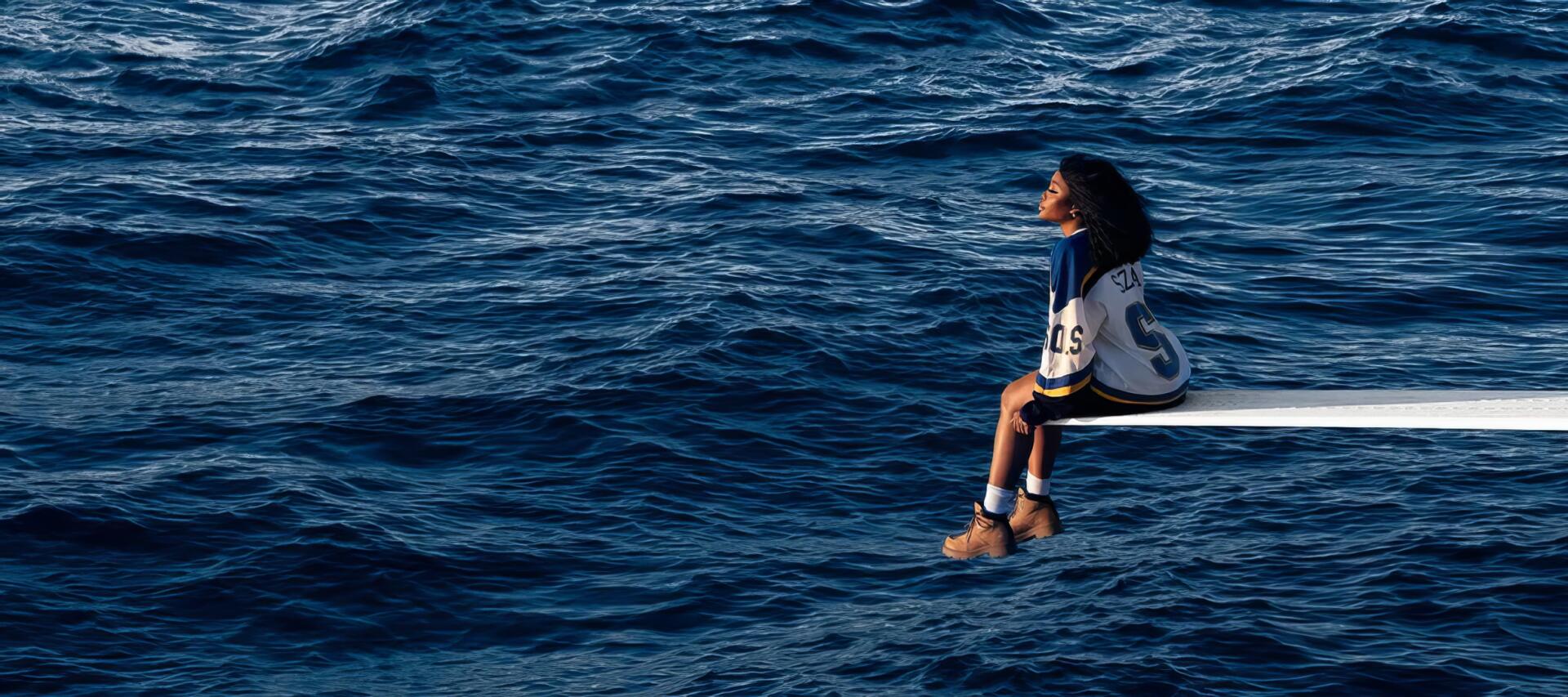 Album-cover style music wallpaper: a singer seated on a diving board over a vast blue ocean, HD PC desktop wallpaper and background.