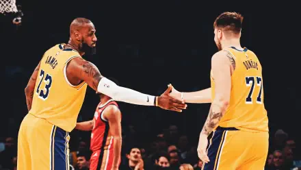 LeBron James and Luka Dončić shake hands on the court, showcasing camaraderie between NBA stars. A vibrant image capturing the spirit of basketball and the Los Angeles Lakers.