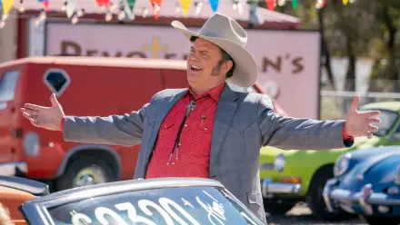 A vibrant HD wallpaper from the TV show Dark Winds, featuring Rainn Wilson in a cowboy hat, enthusiastically presenting a classic car against a colorful backdrop.