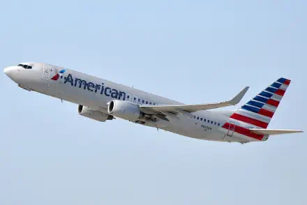 An American Airlines airplane takes off against a clear blue sky, showcasing its distinctive livery. This HD image serves as a striking desktop wallpaper.