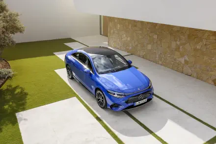 A sleek blue Mercedes-Benz CLA parked on a modern driveway, showcasing its elegant design against a stylish building backdrop. 4K Ultra HD wallpaper for car enthusiasts.