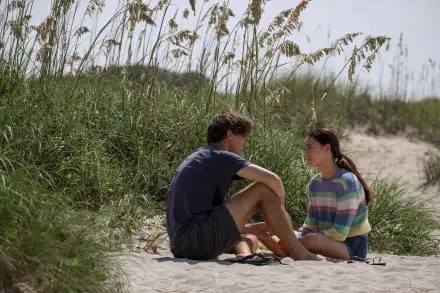 4K Ultra HD desktop wallpaper from the TV show The Summer I Turned Pretty, featuring two characters sitting on a sandy beach surrounded by tall grass.
