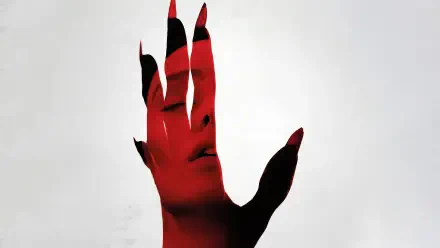 Nosferatu (2024) 4K Ultra HD desktop wallpaper featuring a red-tinted hand with black nails partially obscuring a pale face in the background.