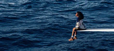 Album-cover style music wallpaper: a singer seated on a diving board over a vast blue ocean, HD PC desktop wallpaper and background.