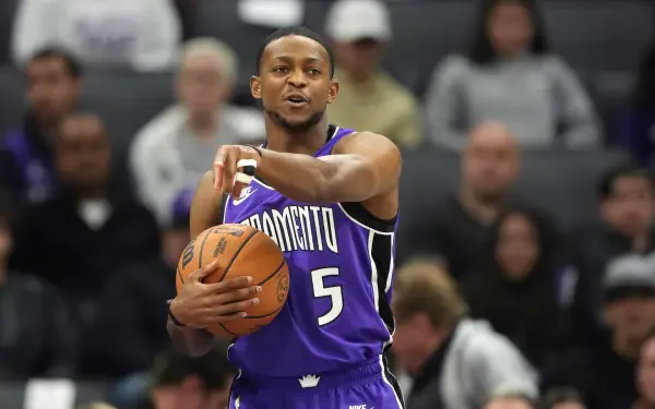 De'Aaron Fox of the Sacramento Kings is shown actively playing basketball, showcasing his skills on the court in an engaging NBA moment. HD background captures the energy of the game.