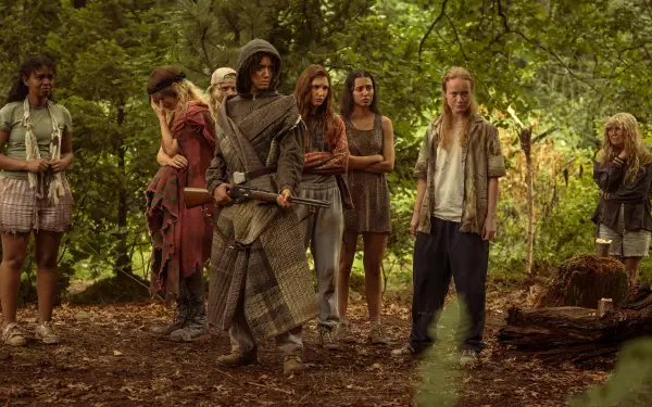 A scene from the TV show Yellowjackets, featuring a group of girls in a forest setting, showcasing their survival struggle with a mix of tension and camaraderie. 4K Ultra HD quality.