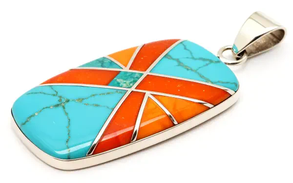 A vibrant pendant featuring turquoise and orange stones, intricately designed with geometric patterns, showcased in a 4K Ultra HD PC desktop wallpaper and background.