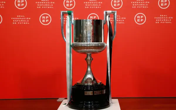 Shiny Copa del Rey trophy displayed against a vibrant red backdrop, symbolizing soccer excellence. This HD image serves as a striking desktop wallpaper.