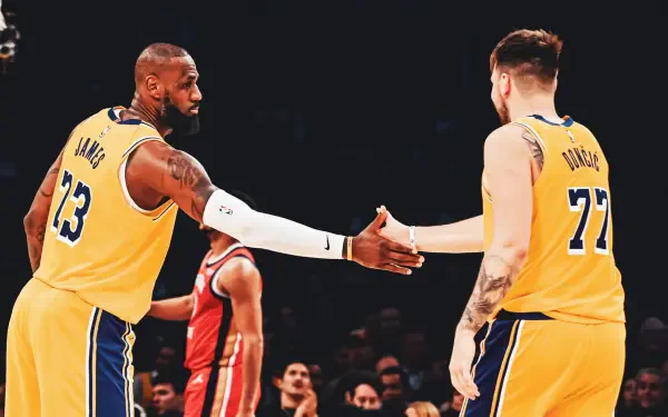 LeBron James and Luka Dončić shake hands on the court, showcasing camaraderie between NBA stars. A vibrant image capturing the spirit of basketball and the Los Angeles Lakers.