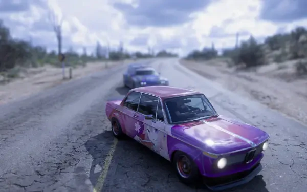 Forza Horizon 5 2K Quad HD PC desktop wallpaper: purple vintage race car with a star decal leads a blue rival along a cracked, dusty road under dramatic clouds.