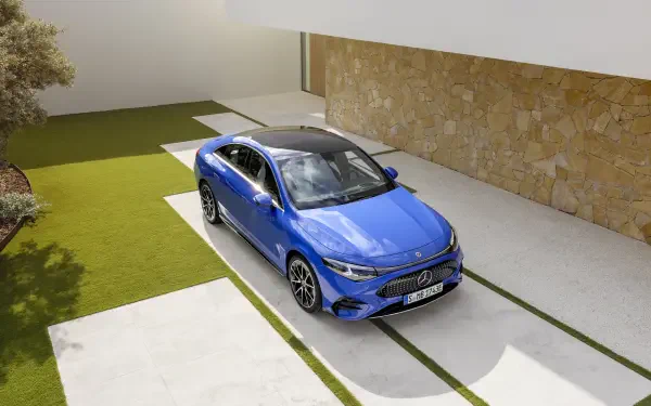 A sleek blue Mercedes-Benz CLA parked on a modern driveway, showcasing its elegant design against a stylish building backdrop. 4K Ultra HD wallpaper for car enthusiasts.