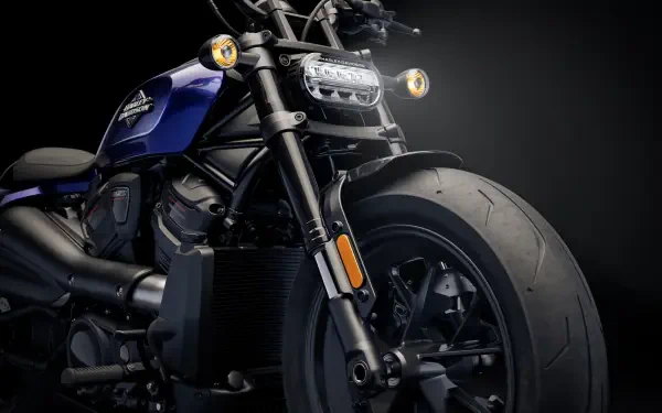 A striking close-up of a Harley-Davidson Sportster motorcycle, showcasing its powerful front wheel and sleek design against a dark background, ideal for a 4K Ultra HD desktop wallpaper.