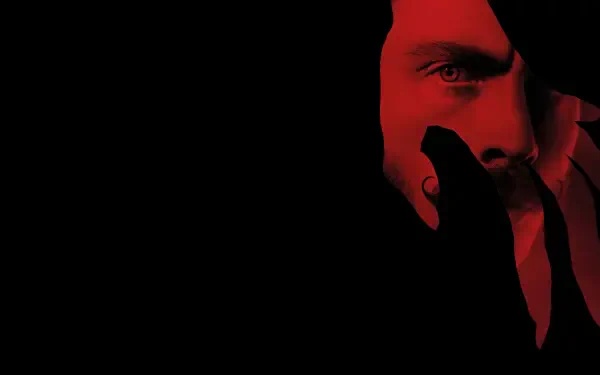 Dark, intense close-up of a face partially obscured in red light, featured as a 4K Ultra HD Nosferatu (2024) PC desktop wallpaper and background.