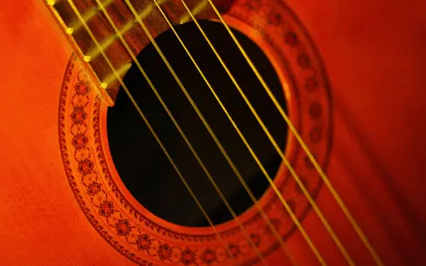 Close-up HD PC desktop wallpaper of a red acoustic guitar: soundhole, rosette and strings highlighted as a musical instrument and music-themed background.
