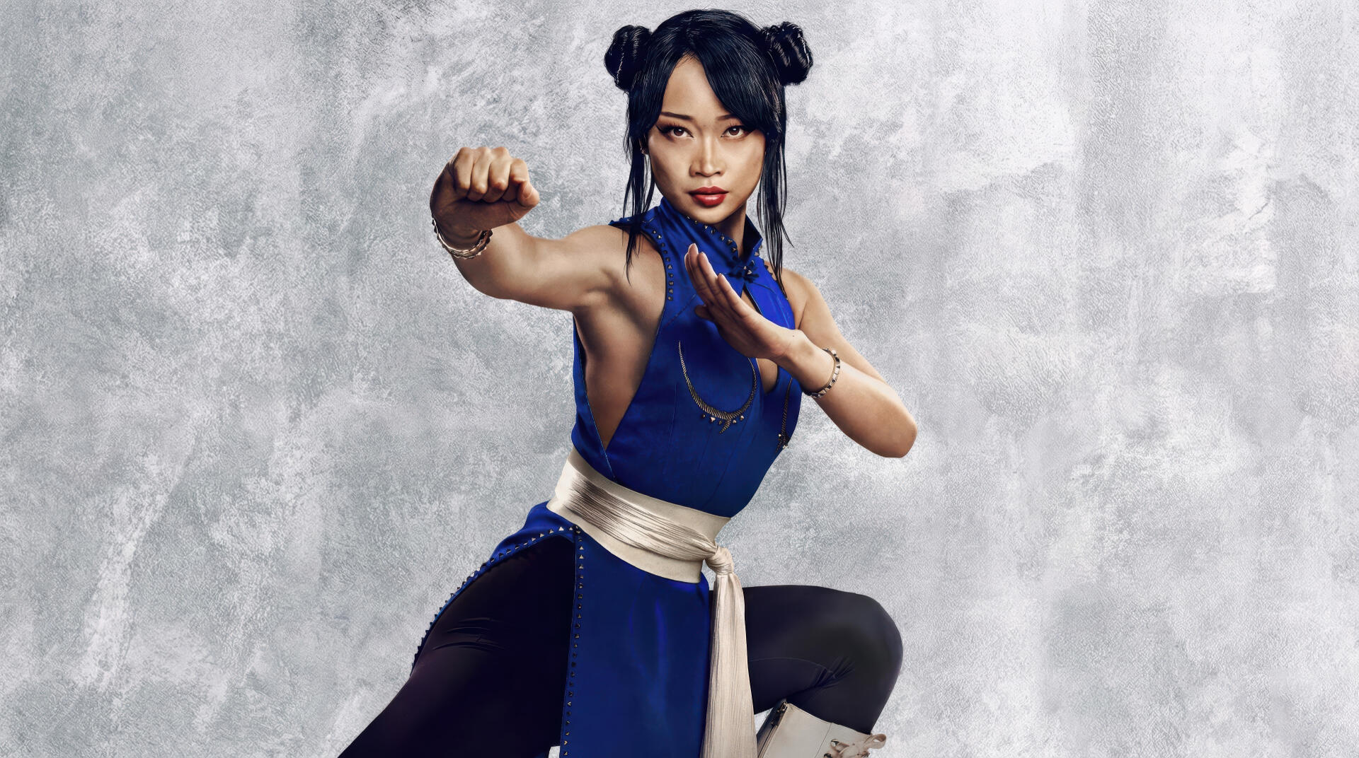 Street Fighter (2026) 2K Quad HD PC wallpaper: female fighter in a blue outfit with white sash, poised in a martial-arts stance against a textured gray background.