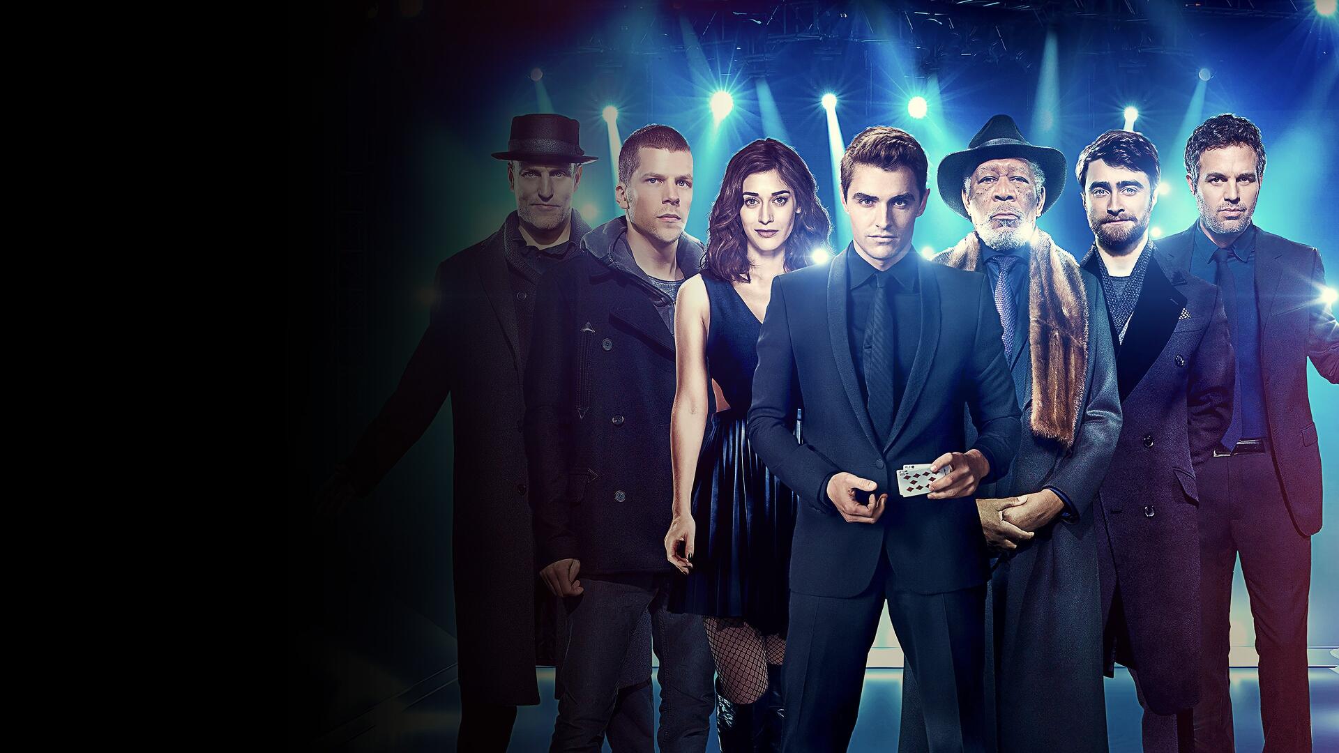 Now You See Me 2 4K Ultra HD PC desktop wallpaper: ensemble of magicians in dark suits and coats, central figure holding a card and cash under moody blue lighting.