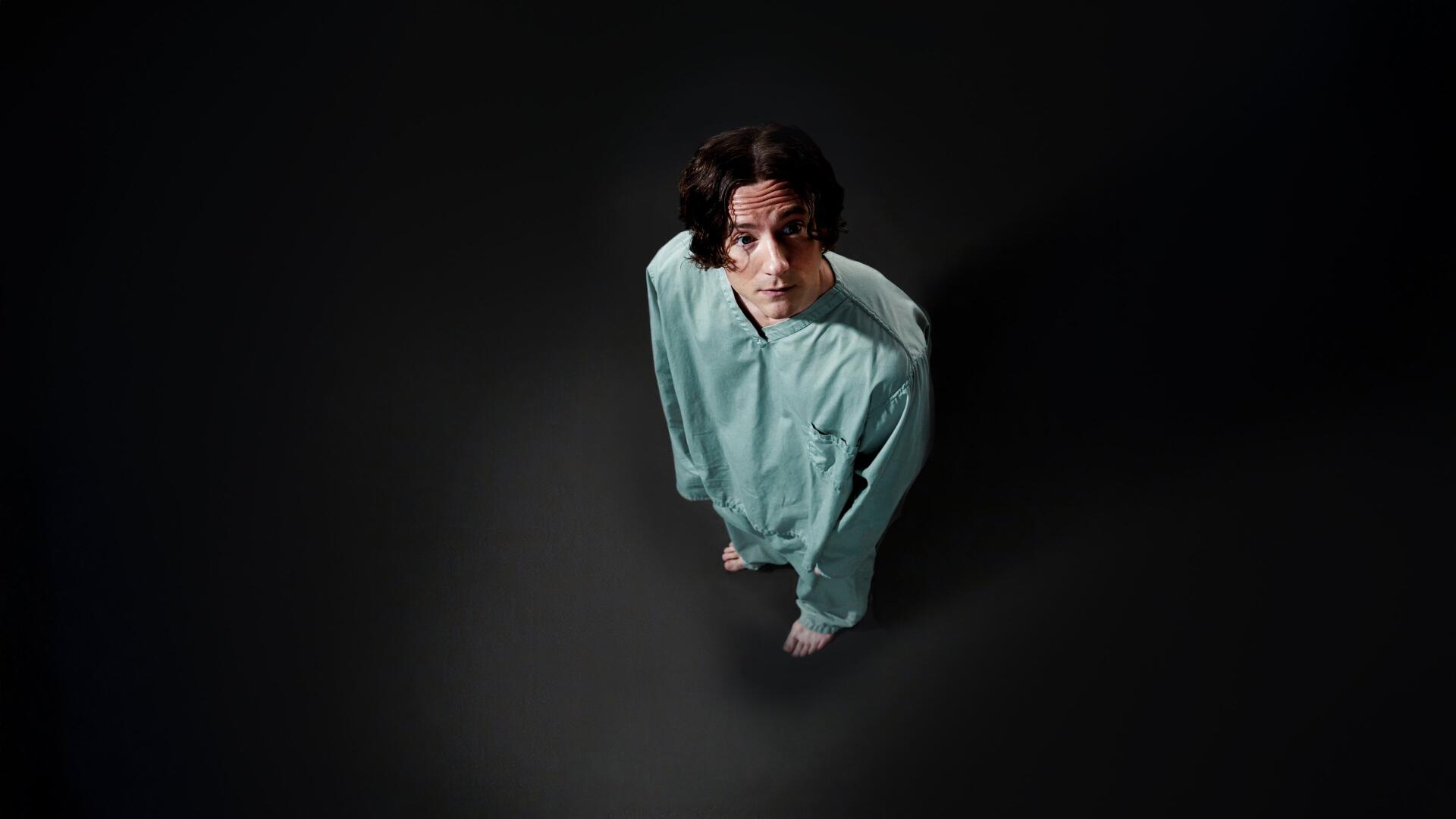 Overhead view of a lone figure in a green hospital gown looking up from a dark void — Thunderbolts* (2025) 4K Ultra HD PC desktop wallpaper.