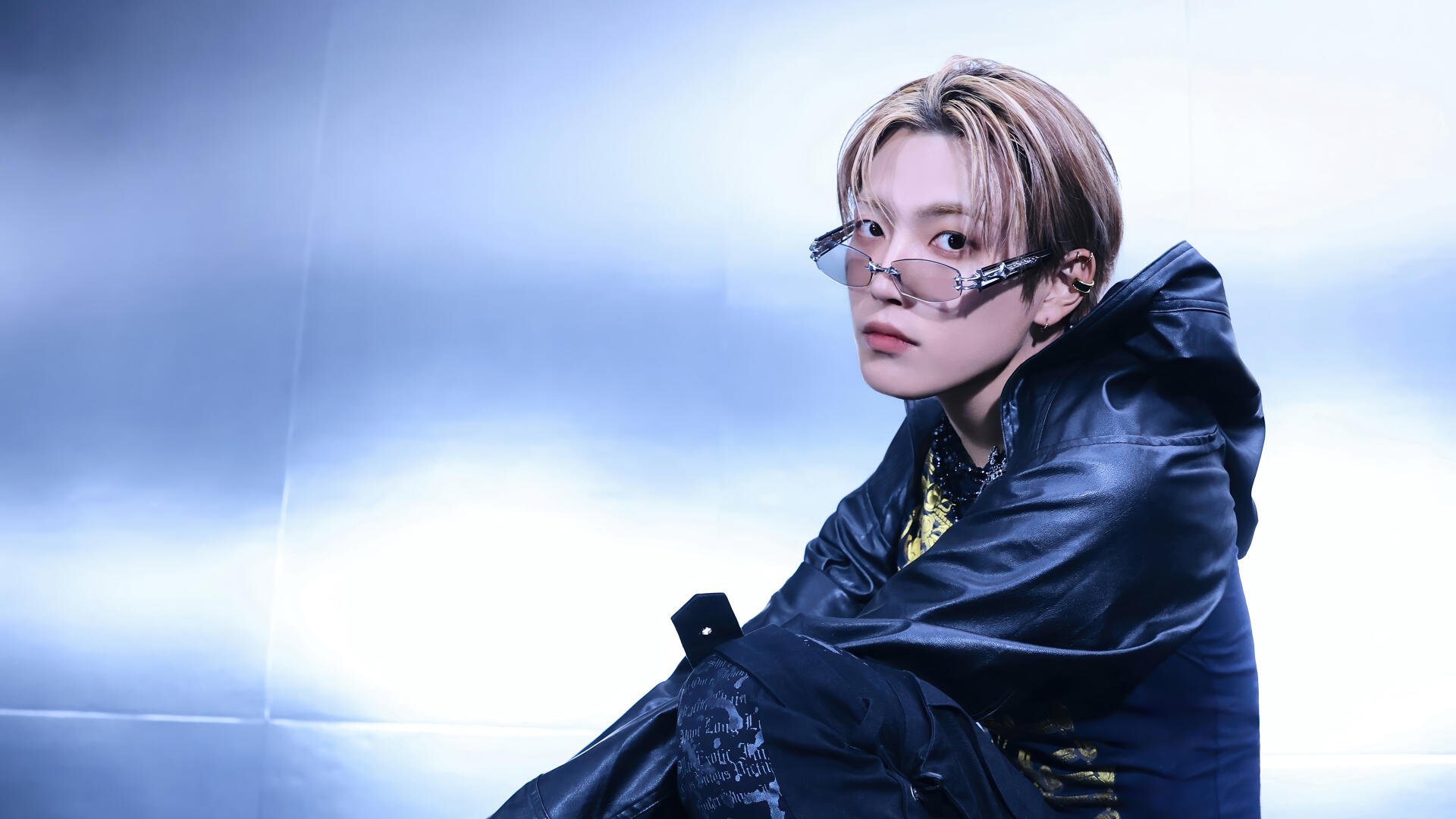 4K Ultra HD PC desktop wallpaper of a K-pop performer in bold, group-inspired stage style: light-haired singer with round glasses and dark layered streetwear against a cool blue backdrop.