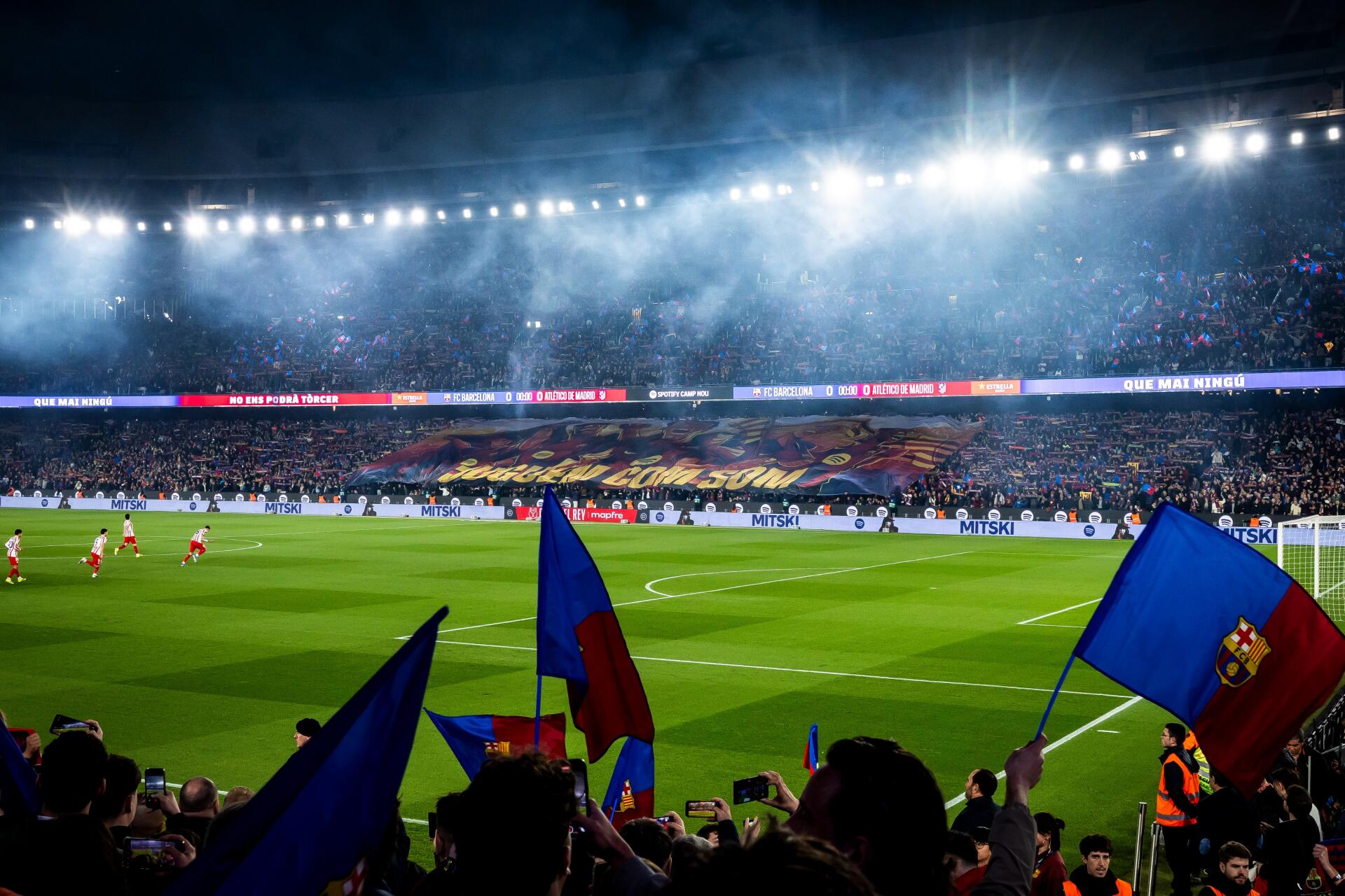 4K Ultra HD PC desktop wallpaper showing a night match at Camp Nou: a lit soccer field in a packed stadium with FC Barcelona fans waving blue-and-red flags.