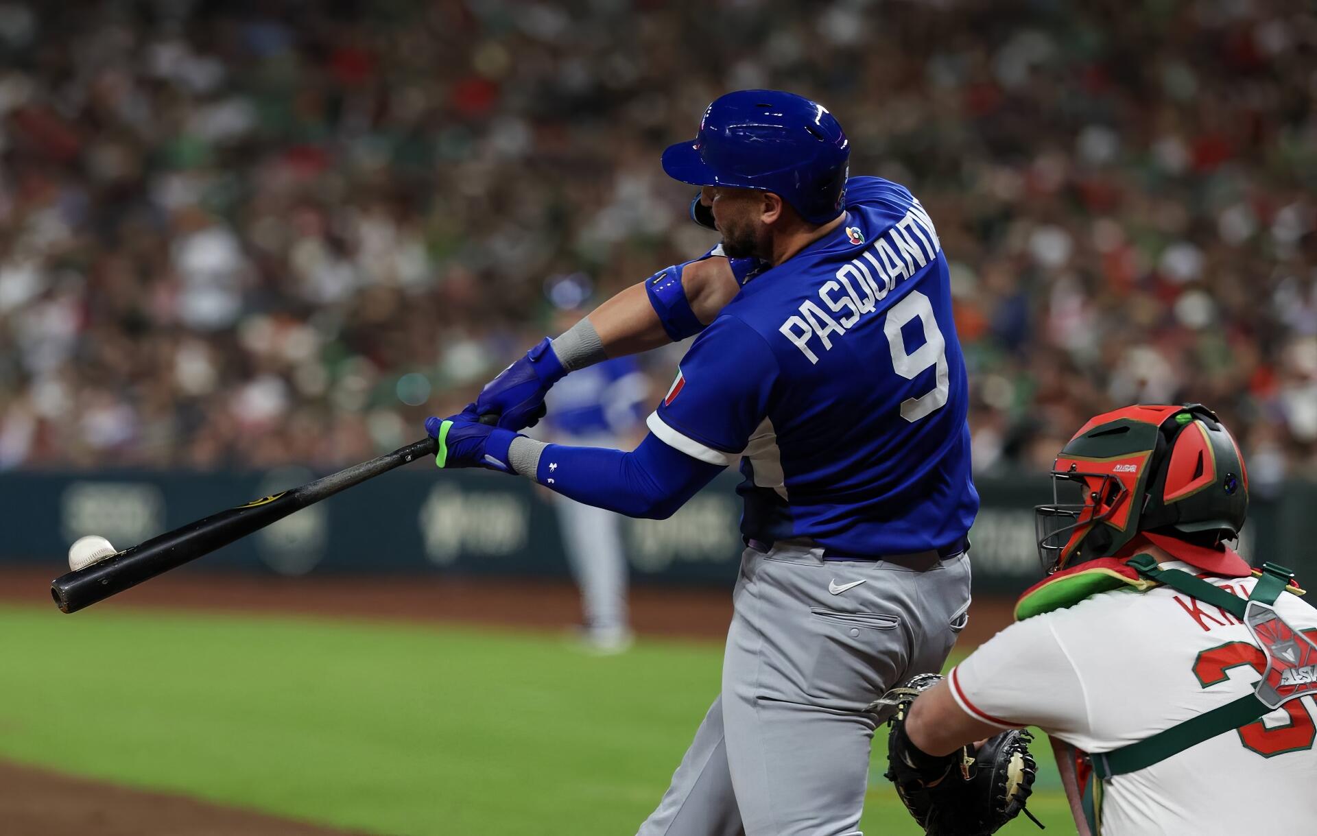 HD desktop wallpaper of a baseball batter in blue swinging during the World Baseball Classic, catcher in green-red gear and a blurred stadium crowd.