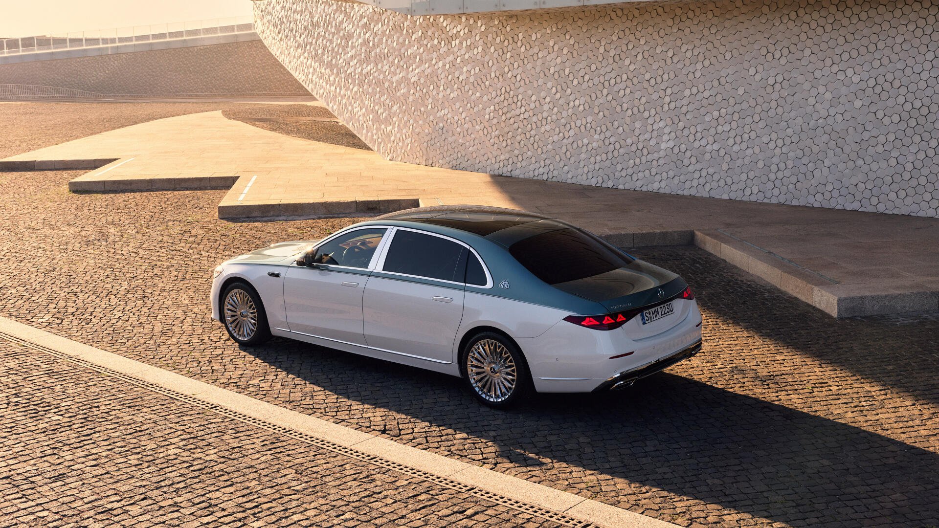 4K Ultra HD PC desktop wallpaper: Mercedes‑Maybach S 680 car in silver, parked on sunlit cobblestone beside modern architectural steps.