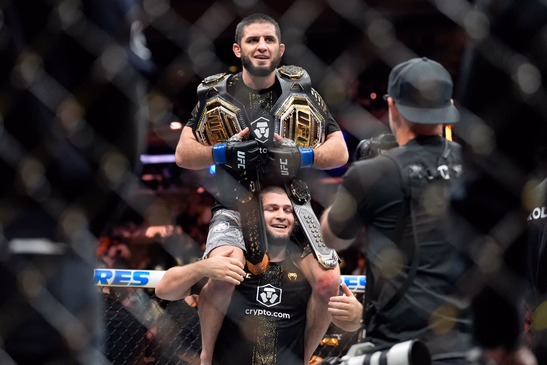 4K Ultra HD wallpaper of two UFC fighters celebrating in the octagon, one hoisted on the other's shoulders wearing championship belts as cameras capture the victory.